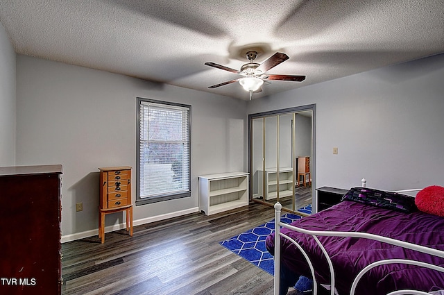 bedroom featuring a ceiling fan, wood finished floors, baseboards, a closet, and a textured ceiling