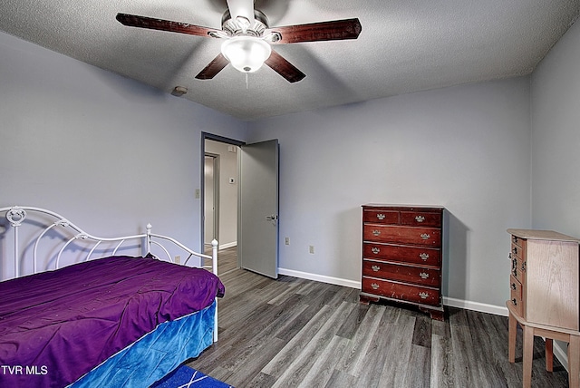 bedroom featuring a textured ceiling, baseboards, and wood finished floors