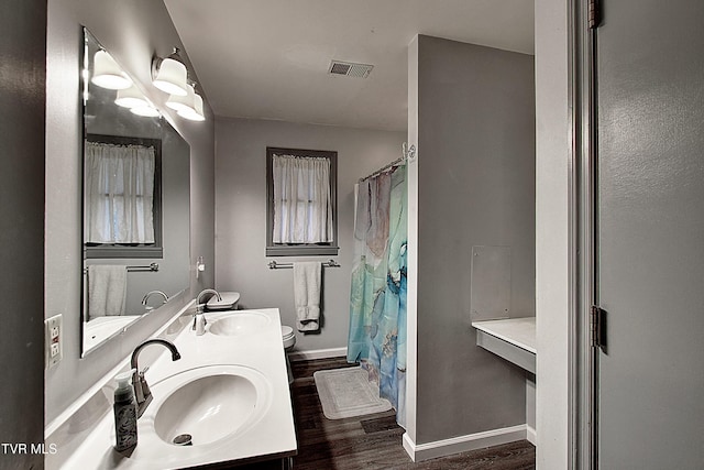 full bathroom with a sink, visible vents, baseboards, and wood finished floors