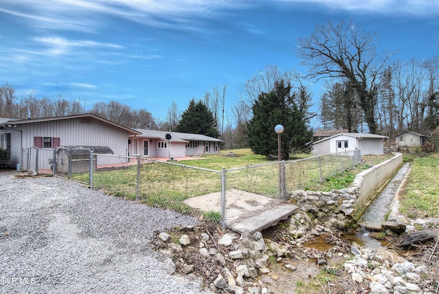 view of side of property featuring a lawn, fence private yard, and a gate