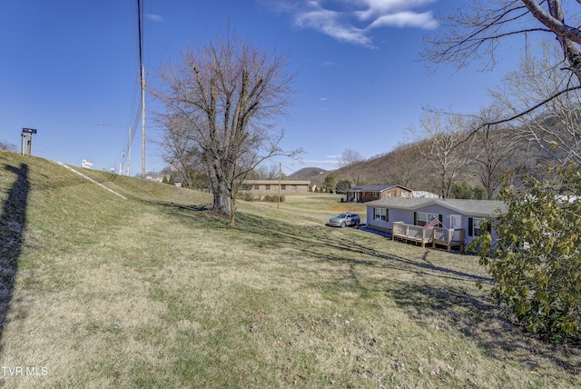 view of yard with a rural view and a wooden deck