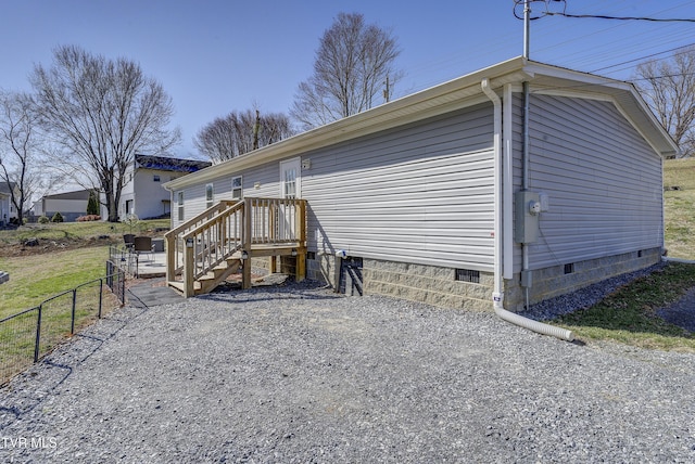 view of side of home featuring crawl space and fence