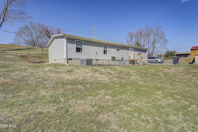 back of property with crawl space, a lawn, and central air condition unit