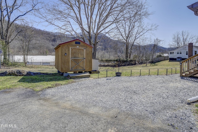 view of yard featuring an outdoor structure, fence, and a storage unit