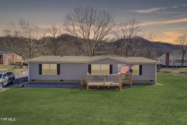 manufactured / mobile home featuring crawl space, a deck with mountain view, and a yard