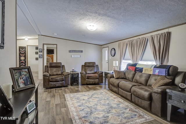 living area featuring ornamental molding, vaulted ceiling, a textured ceiling, and wood finished floors