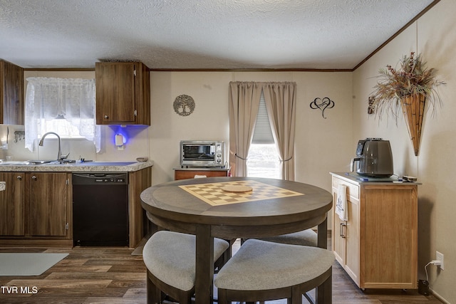 kitchen with a toaster, dark wood-type flooring, a sink, black dishwasher, and a wealth of natural light