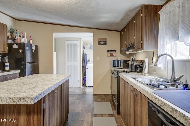 kitchen with a sink, light countertops, dark wood-style floors, black appliances, and crown molding