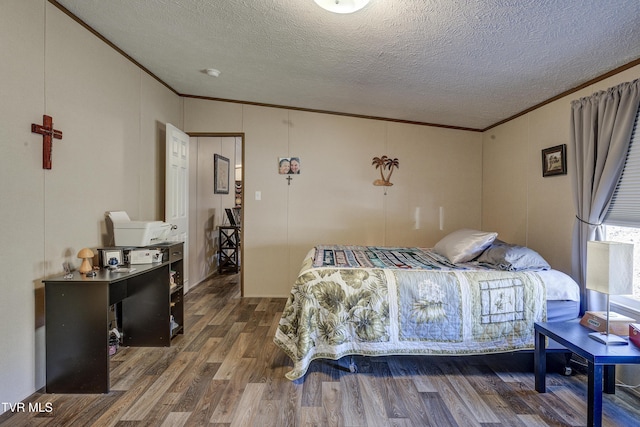 bedroom with ornamental molding, a textured ceiling, and wood finished floors