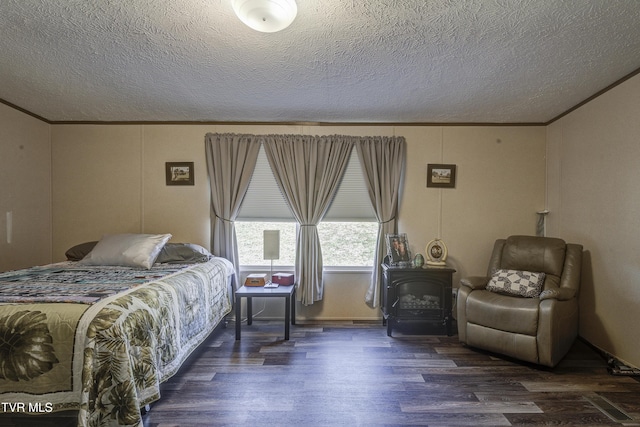 bedroom with a wood stove, a textured ceiling, ornamental molding, and wood finished floors