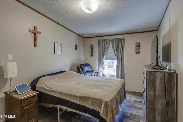 bedroom featuring a textured ceiling, wood finished floors, and crown molding