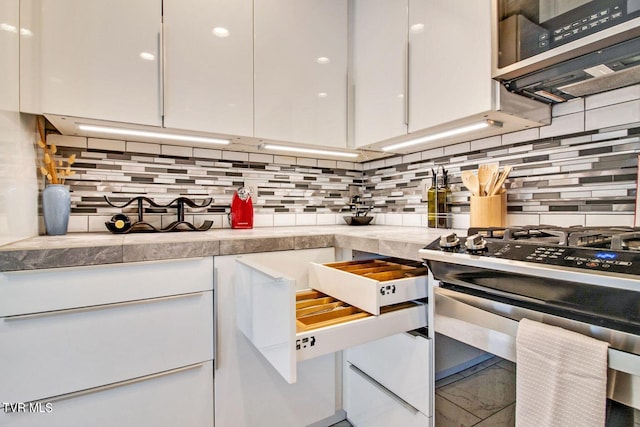 kitchen with appliances with stainless steel finishes, white cabinets, and backsplash