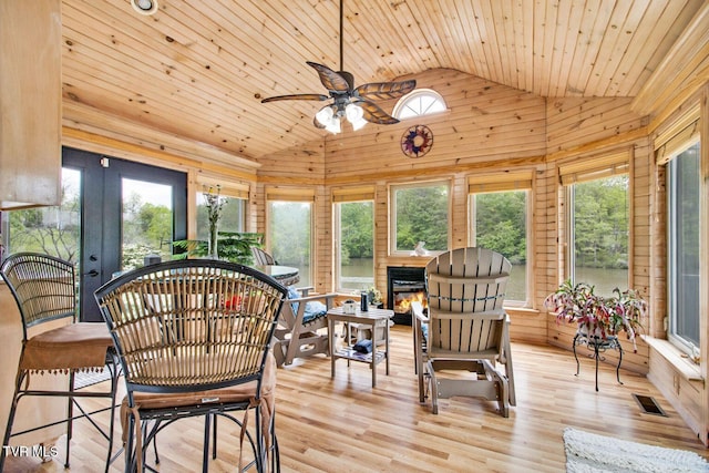 sunroom with lofted ceiling, a healthy amount of sunlight, visible vents, and wooden ceiling