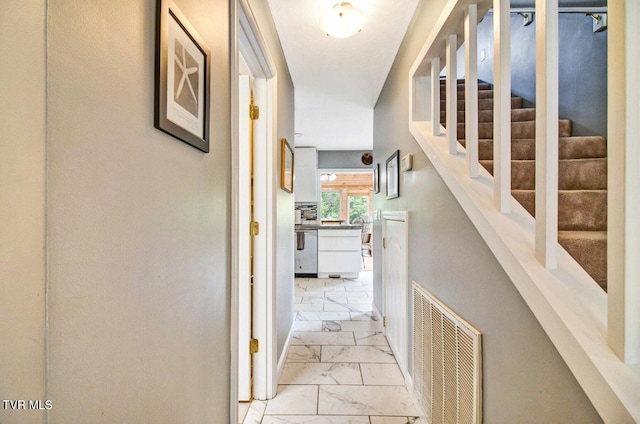 hallway featuring marble finish floor, stairway, and visible vents