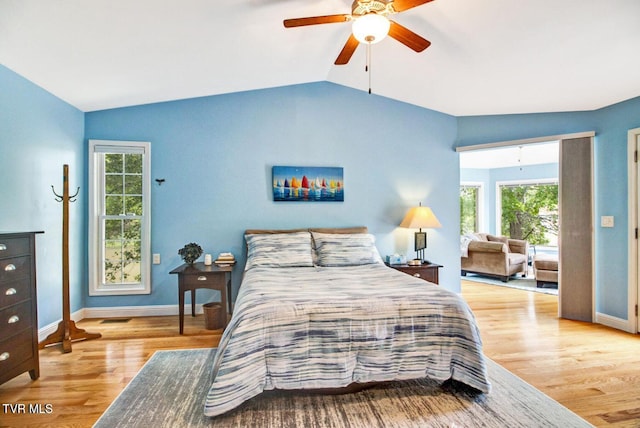 bedroom featuring lofted ceiling, wood finished floors, and baseboards