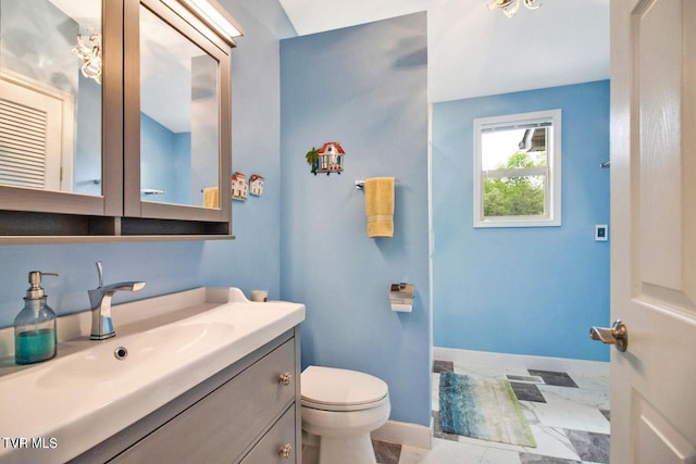 bathroom with marble finish floor, baseboards, vanity, and toilet