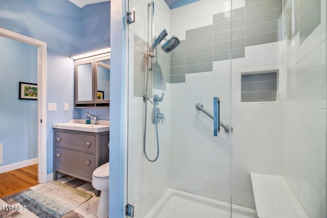 full bathroom with toilet, wood finished floors, a shower stall, and vanity