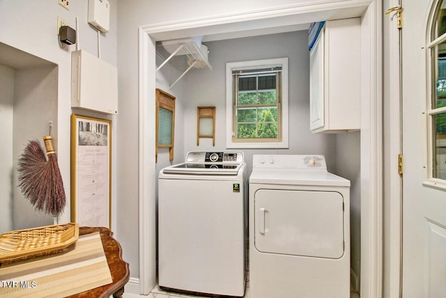 laundry area featuring washing machine and clothes dryer and cabinet space