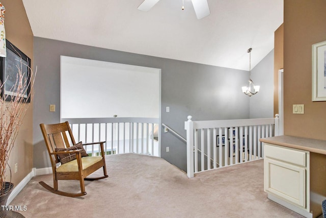 sitting room with lofted ceiling, carpet, an upstairs landing, and an inviting chandelier