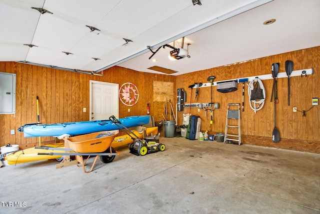 garage featuring a garage door opener, electric panel, and wooden walls