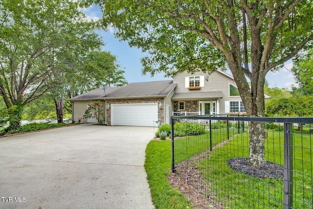 traditional home featuring driveway, stone siding, an attached garage, fence, and a front lawn