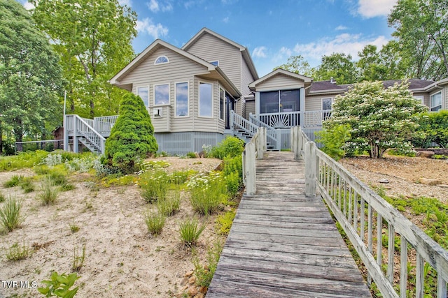 rear view of property with a sunroom and stairs