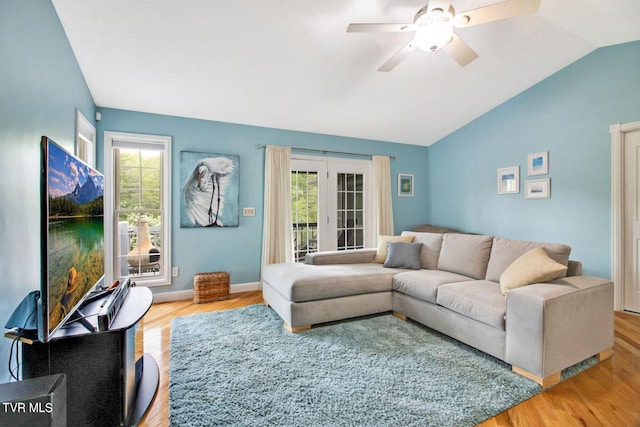 living room with vaulted ceiling, ceiling fan, wood finished floors, and baseboards