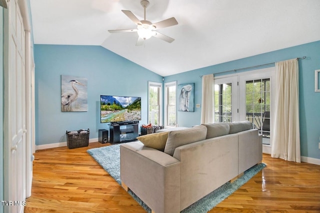 living area featuring lofted ceiling, wood finished floors, a ceiling fan, and baseboards