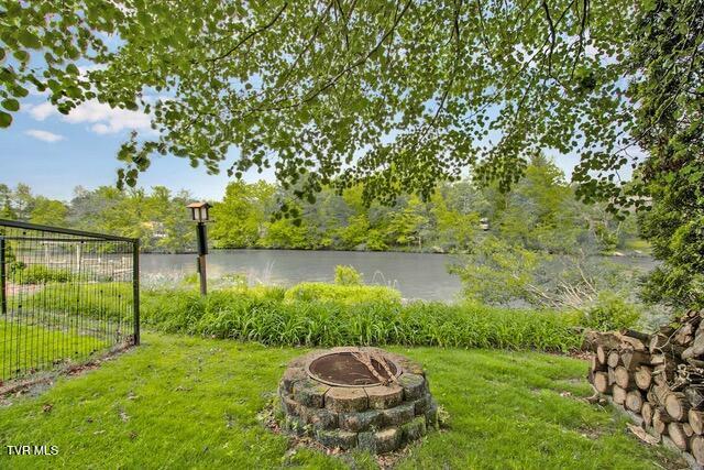 view of yard with an outdoor fire pit and a water view