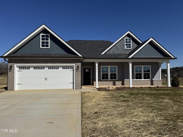 craftsman inspired home featuring board and batten siding, concrete driveway, brick siding, and a front lawn