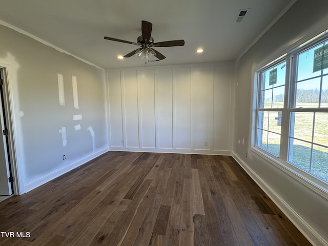 empty room featuring visible vents, baseboards, ceiling fan, dark wood-type flooring, and crown molding