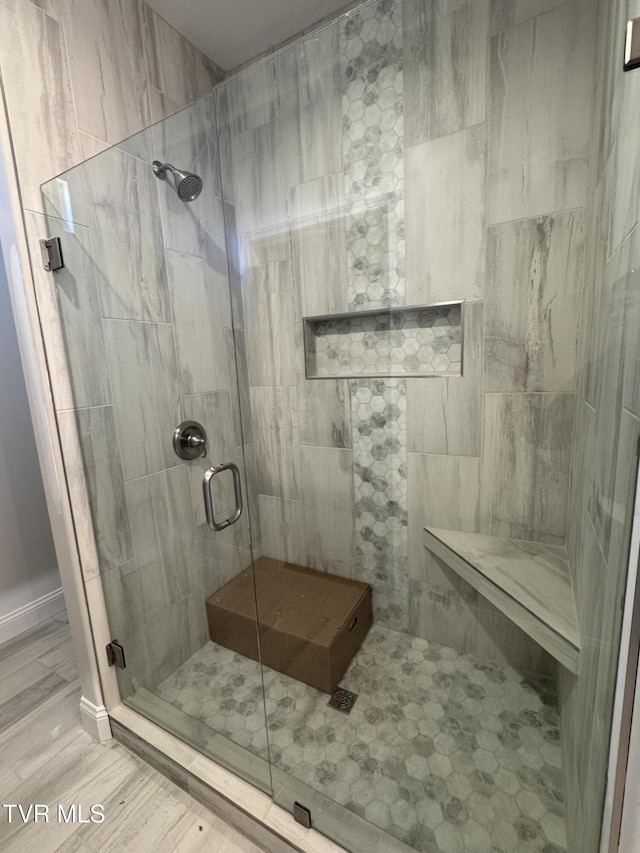 bathroom featuring a shower stall and wood finished floors