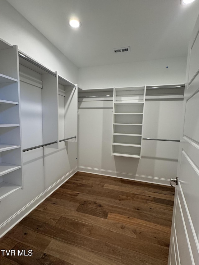 spacious closet featuring dark wood-style flooring and visible vents