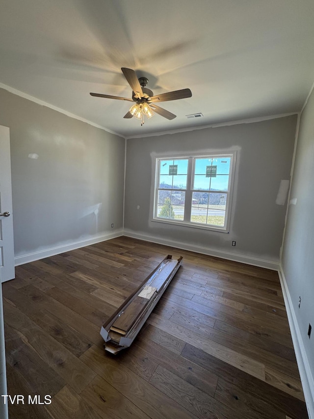 interior space with dark wood-style floors, baseboards, visible vents, and ornamental molding