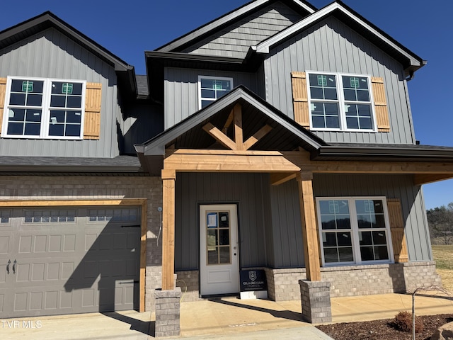 view of front facade featuring board and batten siding, concrete driveway, brick siding, and an attached garage