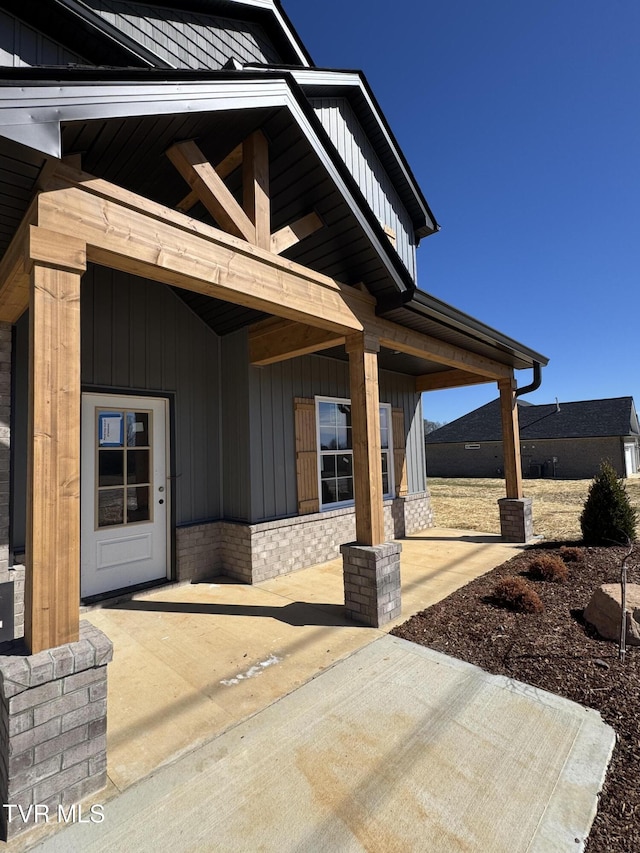 property entrance with a patio and board and batten siding