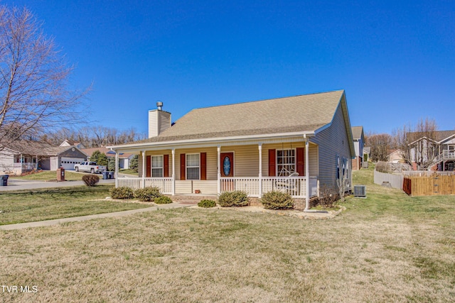 view of front of property featuring a chimney, central air condition unit, covered porch, a front yard, and fence