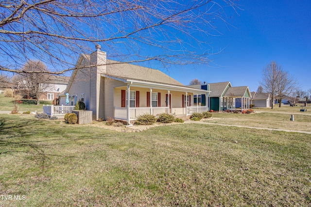 ranch-style house featuring a front yard, covered porch, and a chimney