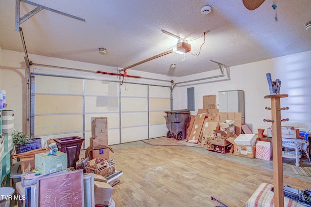 garage with a garage door opener, electric panel, and a ceiling fan