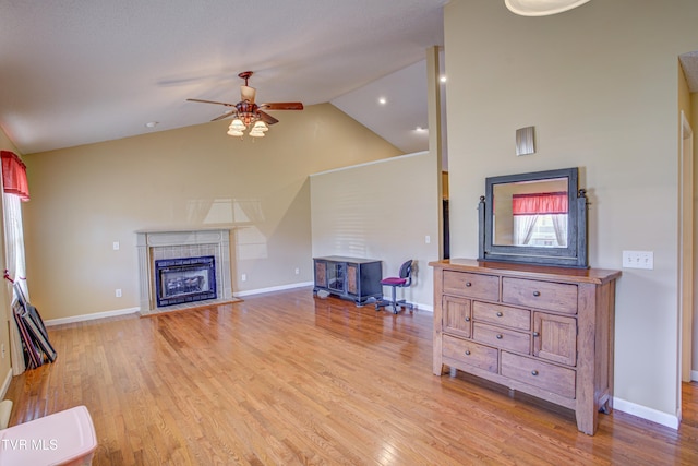 living area with baseboards, a fireplace, and light wood-style floors