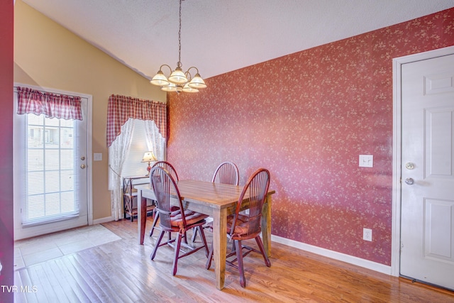 dining space featuring wallpapered walls, baseboards, and wood finished floors