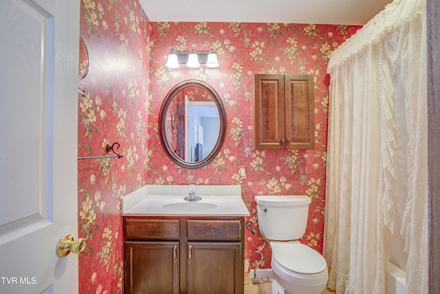 bathroom featuring vanity, toilet, and wallpapered walls