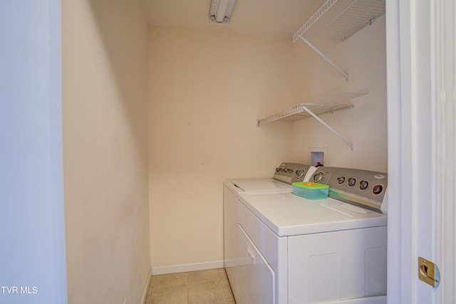 laundry room with laundry area, washer and clothes dryer, baseboards, and light tile patterned floors