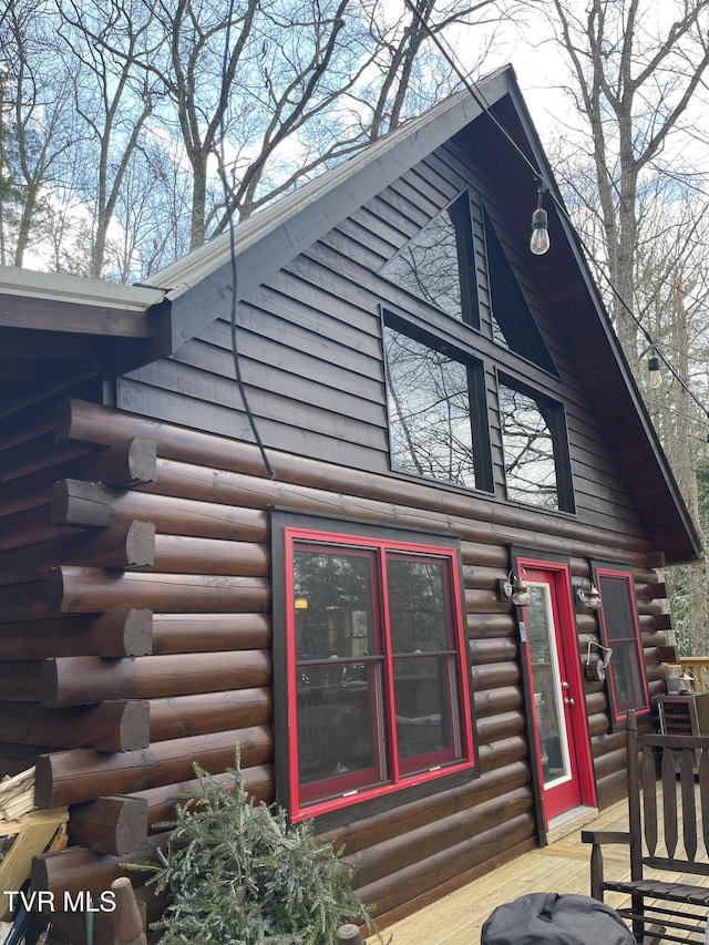 view of home's exterior with a deck and log siding