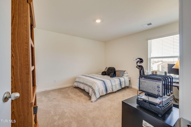 bedroom with light colored carpet, visible vents, and baseboards