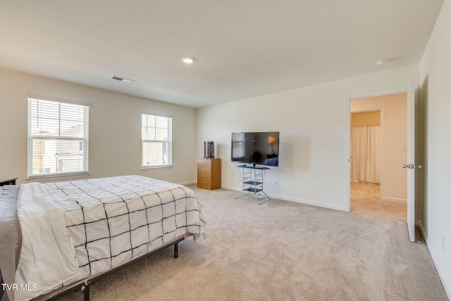 bedroom with light carpet, visible vents, and baseboards