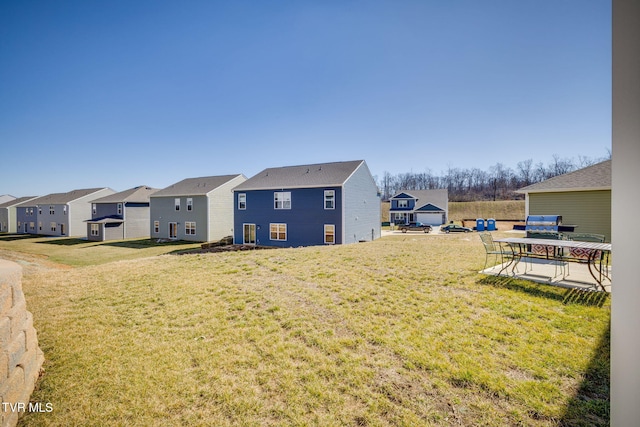 view of yard with a residential view and a patio