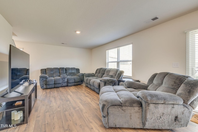 living room featuring light wood-type flooring, visible vents, and recessed lighting