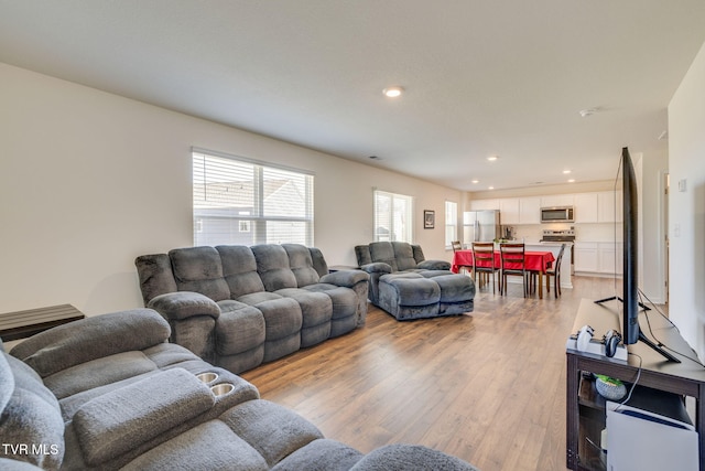 living area with recessed lighting and light wood-style floors