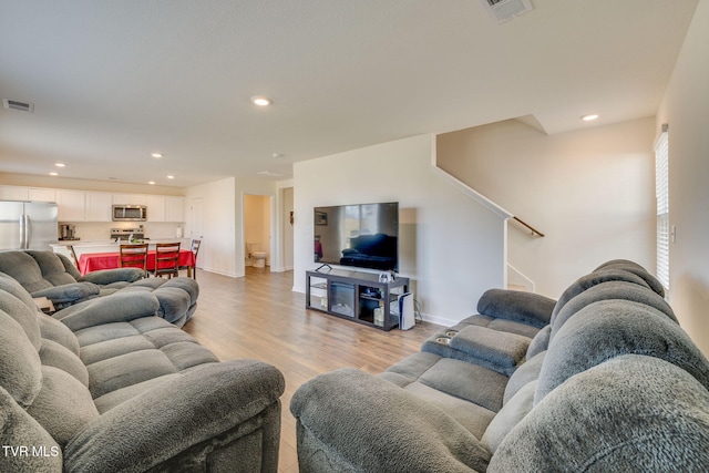 living area with light wood-style floors, stairs, visible vents, and recessed lighting